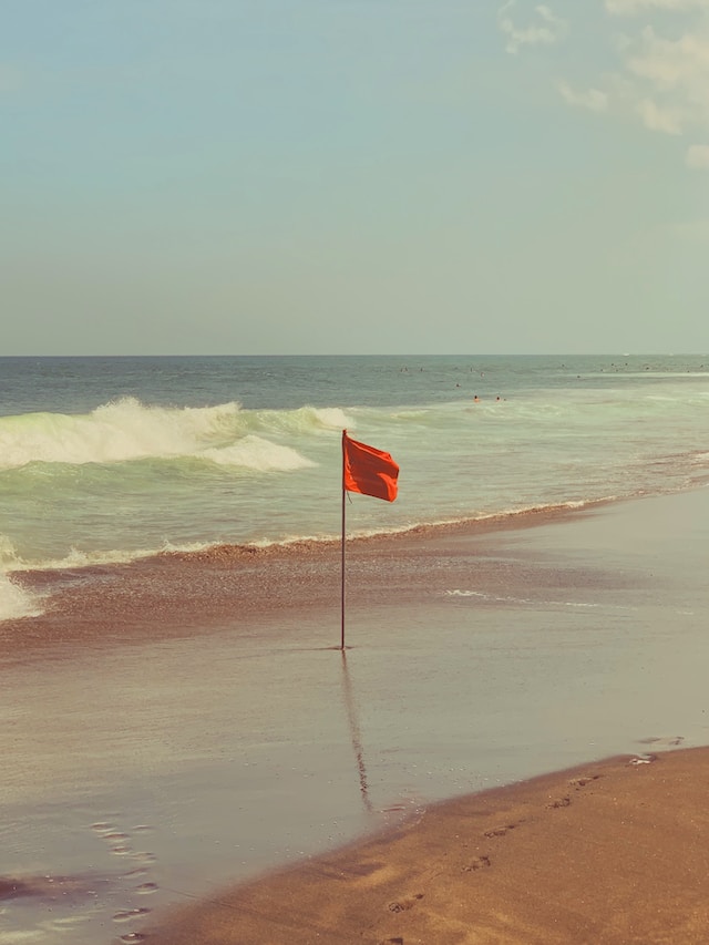 Red flag on a short pole on a beach