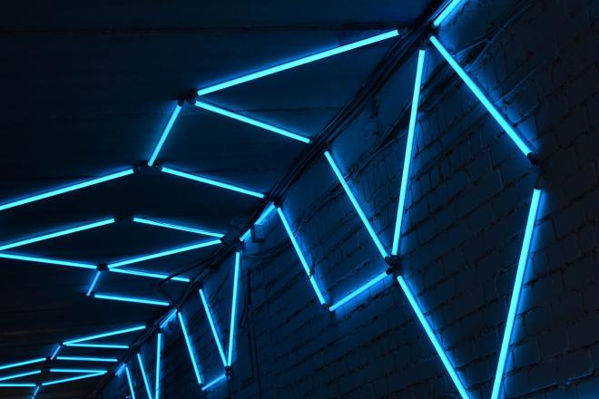 Blue neon lights along a dark hallway