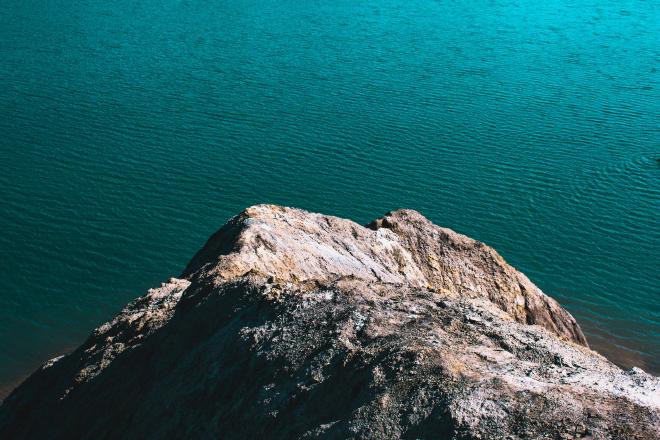 Rocky cliff in front of a blue green ocean