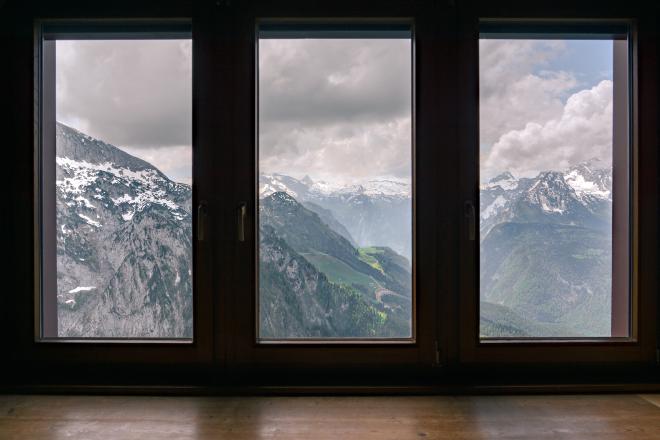 Three tall windows with a view of snow-capped mountains.