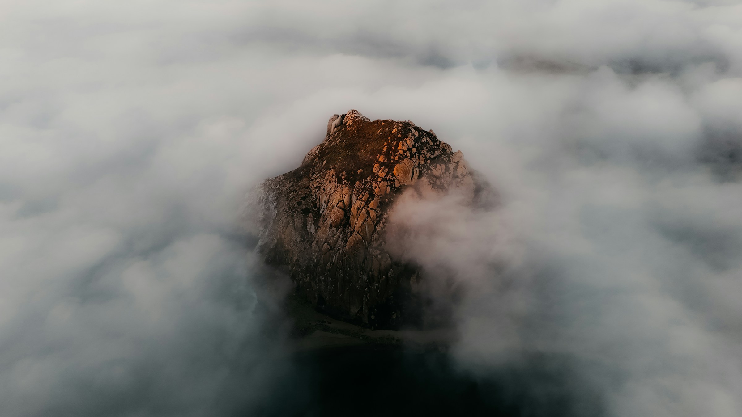 Rocky island surrounded by clouds